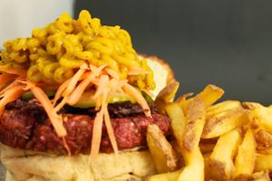 Burguer de lentilha com beterraba (125g), pão vegano, maionese de salsinha, pasta de abóbora com sal negro, cenoura ralada, pepino japonês e finalizado c/ repolho roxo carameliz at Gunas Burguer in Sao Paulo
