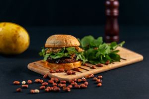 Burguer de feijão preto c/pão vegano levíssimo, maionese de salsinha com assafétida, pasta de amendoim c/maracujá, berinjela caramelizada c/açúcar demerara e rúcula da terr at Gunas Burguer in Sao Paulo
