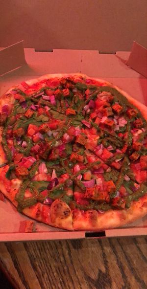 Pizza with tomato sauce, veggies, seitan and vegan pesto at Marquis Pizza in Denver