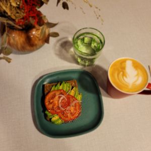 "Avokado lings" rye bread with avocado, red onion, and tomato), and "stjernelatte" (oatmilk latte with star anis)  at Coffeeberry in Sandnes