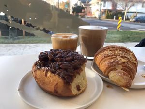 Cinnamon bun, almond croissant, hot choc and flat white  at To Live For in Vancouver