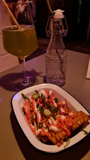 Fried corn with truffle mayo and pink wasabi mayo next to a mocktail at Let‘s be Frank in Vienna