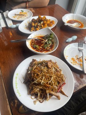 (Front) special fried noodles, sichuan style, (middle) remains of the man-and-wife, (back) hot and fragrant deep fried tofu with sweet potatoes  at Tofu Vegan - Spitalfields in East London