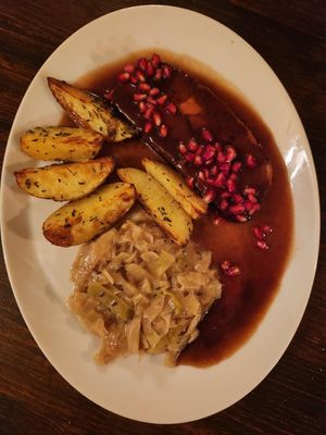 Seitan roast with parsnip, gravy and pomegranate seeds, roasted potatoes, and white cabbage. at Vaust Braugaststatte in Berlin