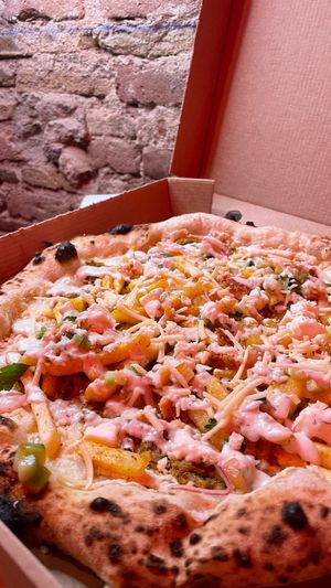 Pizza “Greek Gyro” base blanco pollo veg butcher papas fritas salsa de tomate e hierbas queso feta casero de Almendras Muzza vegetal salsa de ajo y orégano. 12€  at El Vato Loco in Barcelona