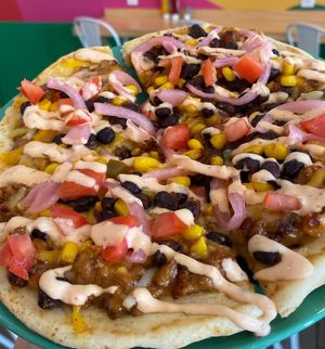 Fire Flatbread with carne con queso, Mexican mixed cheese, black bean and corn salsa, pickled onions, diced tomatoes, and Baja ranch at devil's lettuce in Richmond