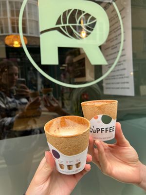 Coffee in take out edible cups in front of the Remedy front window at Remedy Coffee Shop in York