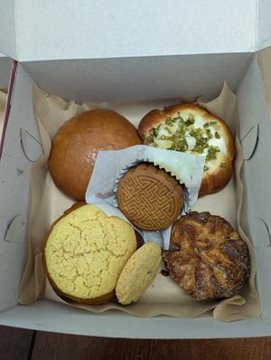 Inside the Mid-Autumn Festival box, scallion bun, koign amann, almond cookie, pineapple bun, mushroom BBQ bun, and double "yolk" moon cake! at Tai Zhan Bakery in Saratoga