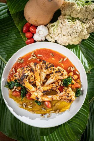 Grilled Couliflower with butternut squash puree and tomato souce, sauted chard and sesame seeds. at Maxan in Antigua