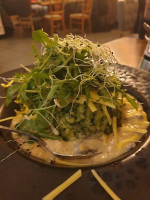 Spinach knödel with mushroom cream sauce and grated cheese and rucola on top at The Keep Garden Kitchen in Salzburg