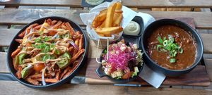 L: Sweet loaded patatoes with jackfruit, cheese and guacamole etc. R: typical zuurvlees from the region with local mushrooms, fries and salad at Breakaway in Sint Geertruid
