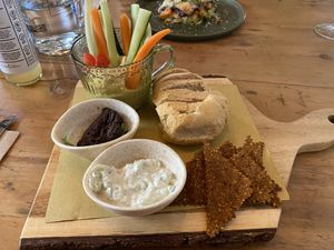 Plankje met hummus, rauwe groenten, tatziki, soort tapenade, brood en (rauwe?) crackers. Smaakte goed. Crackers en hummus met groente was erg lekker.  at Naturalmente in Sevilla