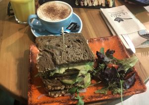 Pineapple smoothie, oat cappuccino and vegan sandwich (rocket, hummus, avocado, tomato)  at La Mala Brunch - Setas in Sevilla