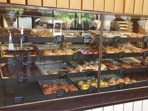 Vegan options marked with a V on labels as well as on the wall behind the cashier  at Revolution Doughnuts in Decatur