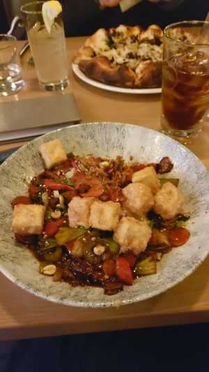 Hunan Kung Pao and pizza in the background at Earls Kitchen + Bar - Test Kitchen in Vancouver