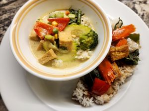 Green curry in the bowl and Pad Kra Pao alongside, both over rice.   at Superb in Nampa