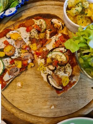 Pizza served with side of green salad and smashed roast potatoes at Bonita Cafe and Social Club in Bangkok