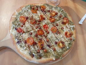 Pizza ganso 🪿 garbanzo 🧆. Base de pesto, queso vegan, garbanzos crocantes, tomate Cherry. at Casa Hoja in Pereira