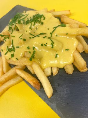 Cheezy Fries: Crispy thin cut fries topped with the most insane vegan cheese that we created sprinkled with fresh chives at Dirty Vurgerz in London