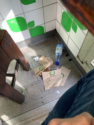 The whole floor is littered is garbage and food at Maoz - Muntplein in Amsterdam