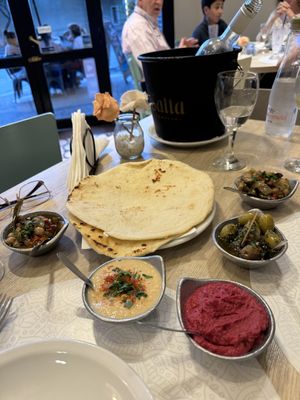 Snack optiones are different hummus and pickles and olives and pita breadd  at Dubai Comidas Árabes in Salta