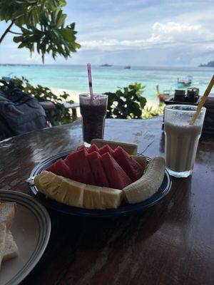 Large fruit plate, smoothies and the beach in the background   at Paradise Pearl in Koh Phi Phi