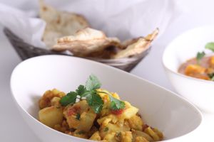A spring-like dish! A vegetarian delight! Potatoes, tomatoes, cauliflower, cilantro, masalas, & spices. at Maurya's.Rest.Bar.Banquet in Kamloops