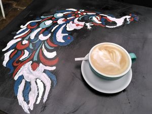 Oat milk latte and lovely peacock 🦚 (January 2023) at The Perky Peacock in York