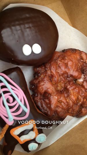 Vegan apple fritter and voodoo doll at Voodoo Doughnut Too in Portland