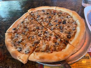 Whole vegan pizza with myokos cheese, black olives, and vegan sausage  at Satchel's Pizza in Gainesville