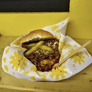 “THE SLOPPY” Sloppy Jo - Slow cooked Mince and Onions on a fat rol with fresh onions, pickles and a salt bae of cheese  at THE COVEN of WICHES in East London