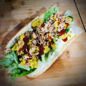 THE CORRIE - Classic Warm Baguette stuffed with Curried Coronation CHKN and floppy greens, topped with Mango Chutney Ketchup and Crispy Onions at THE COVEN of WICHES in East London