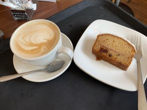 Oat milk latte and cherry bakewell loaf cake  at Dnisi in Stranraer