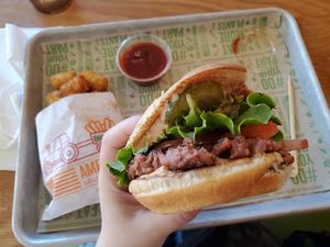 Classic burger with special sauce and small tator tots at Next Level Veggie Grill – Ballard in Seattle
