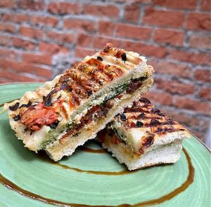 Focaccia de tomates secos, crema untable de marañón a las hierbas, pimentón asado y rugula. at Momentum in Cali