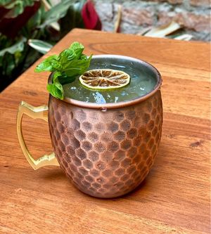 Gin mule con ginebra, ginger beer 100% artesanal, tintura madre de hojas de coca y pipilongo. at Momentum in Cali