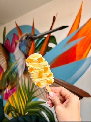 Paleta de mango de azúcar, mermelada de duraznos y chocolate blanco de coco. at Momentum in Cali