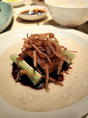 Assembled wrap featuring plant-based Peking 'duck', housing sauce, cucumber at Mott 32 Bangkok in Bangkok