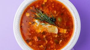 Vegan Solyanka: three types of vegan sausage, carrots, minced soy, tomato paste, pickled cucumbers, potatoes, bell peppers, olives, lemon, vegan mayo at Fibonacci in Almaty