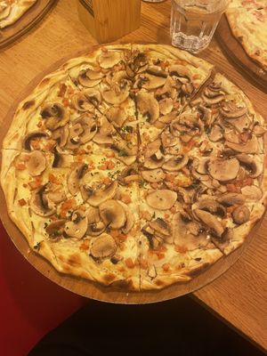 A classic flamenkueche — lots of mushrooms and La Vie ‘bacon’ on a lactofermented soy cream  at L'Alsacien République in Paris