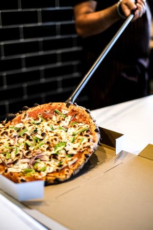 Take a glimpse into the skilled art of our chef as he carefully boxes up a hot, delicious vegetarian and vegan pizza fresh from our wood-fired style oven at Papa G's Pizzeria in Blacktown