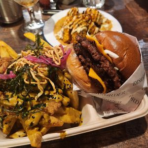 Bacon jam vegan smash burger with katsu loaded fries and corn ribs in background at Disorder  in Manchester