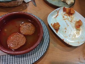 Chorizos a la sidra y patatas bravas, foto tardía at Puzzle Bar in Gijon