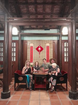 Sitting at the 100 year old table all 6 of us very full after a great dinner! at Muro Organic Vegan Restaurant in Nha Trang