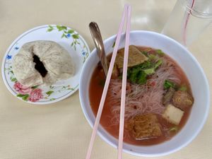 Steamed oat BBQ bun and Thai style noodles with pink tofu saucee  at Sutunthip Vegetarian Food in Bangkok