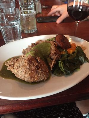Blue corn crusted seitan medallions with yams, black beans, rice, greens and tomatillo sauce at New World Bistro Bar in Albany