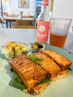 Gluten-free version of their vegan smoked tofu sandwich with spinach and dried tomato+almond spread plus baked potatoes and olives  at Panorama Bar Bazar in Mallorca