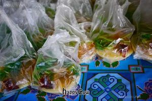 Sacks of yellow tofu with condiments at Weekly Market in Chiang Mai