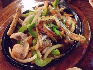The sizzling half of the vegan fajitas with tofu. at Pokez in San Diego