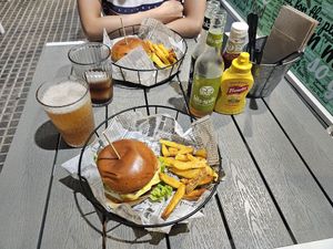 American burger in the front and BBQ burger in the back. Ketchup and mustard are included for the fries and free of charge at Rúkula Vegan Food in Malaga